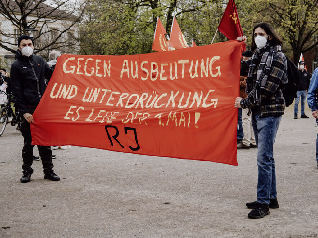 <br/>Zwei junge Gewerkschafter*innen positionieren sich am 1. Mai "Gegen Ausbeutung und Unterdrückung" bei der Kundgebung in Bielefeld.